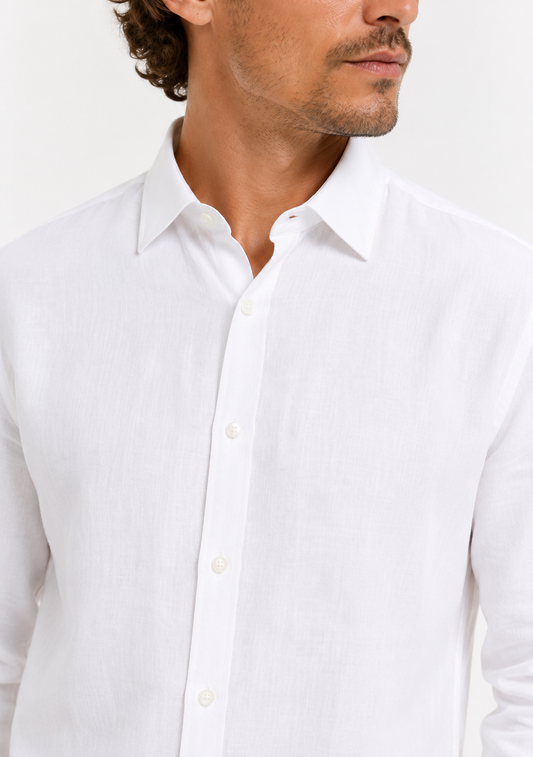 A close-up of a man wearing a white long-sleeve linen button-down shirt, showing the collar, front buttons, and textured fabric against a plain white background.