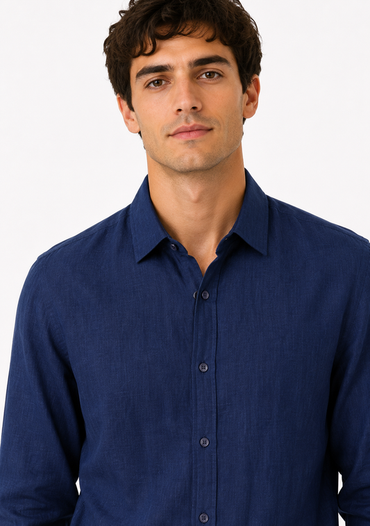 A man wearing a dark blue long-sleeve linen button-down shirt, shown from the chest up against a plain white background.