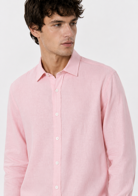 A man wearing a light pink long-sleeve linen button-down shirt, shown from the chest up against a plain white studio background.