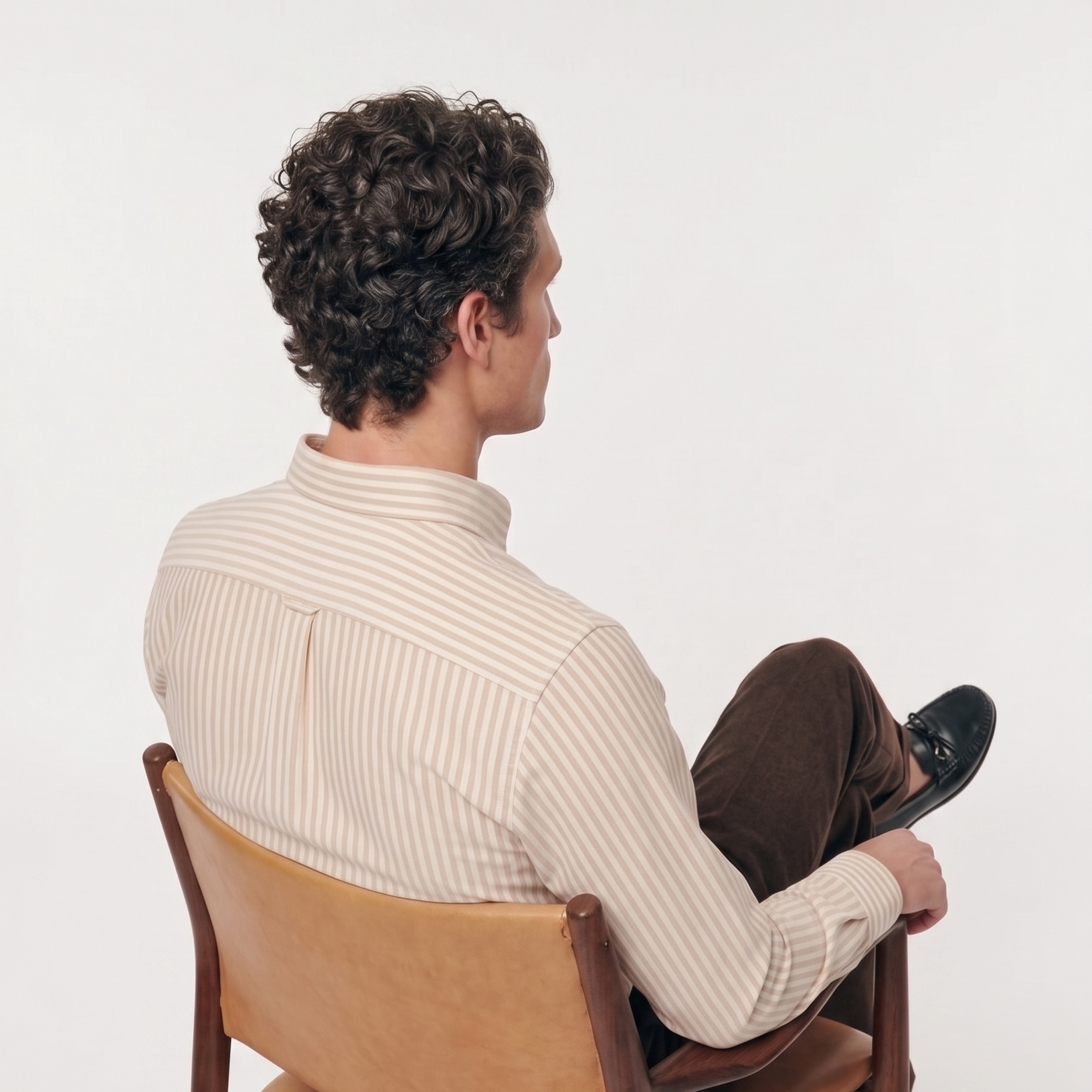 Back view of male model wearing premium classic beige striped Oxford shirt