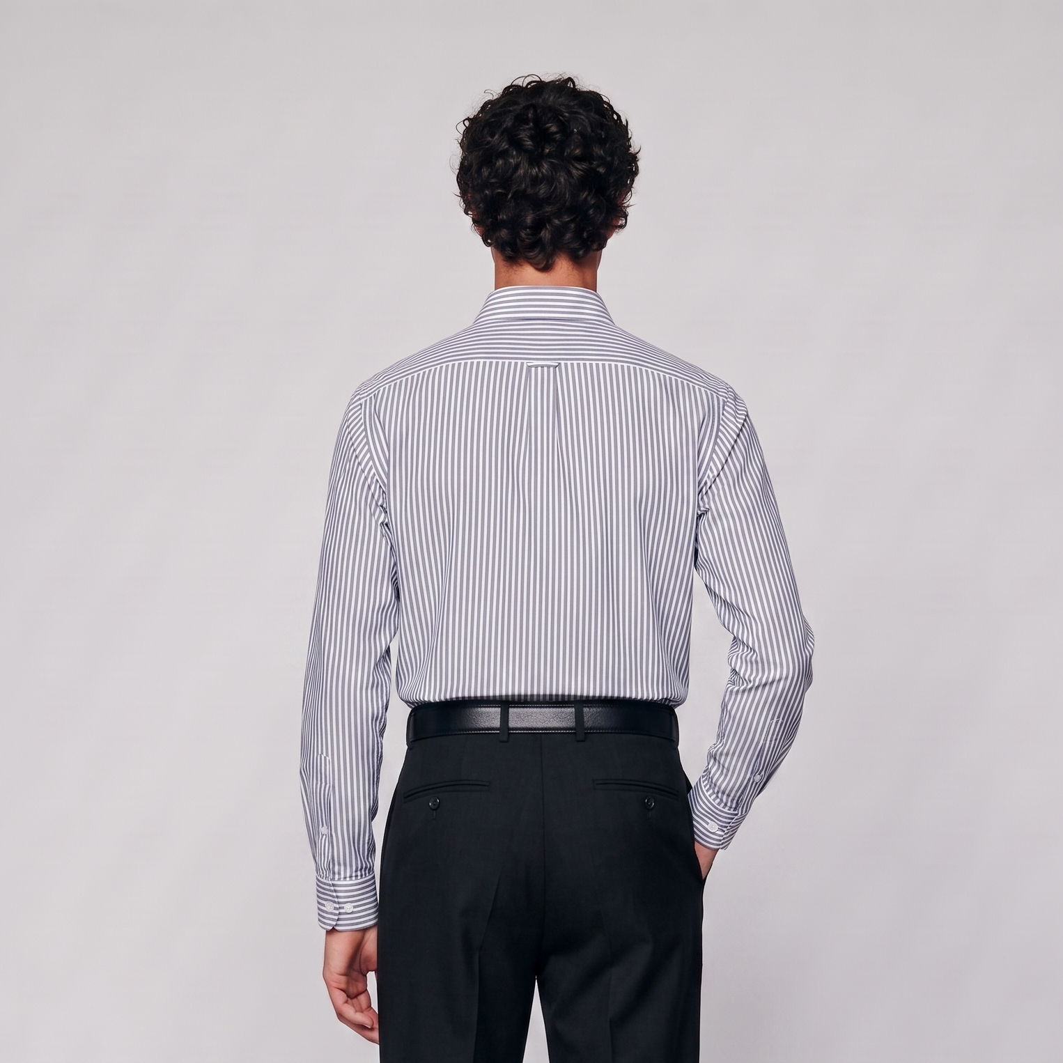 Back view of male model wearing premium navy blue striped Oxford shirt
