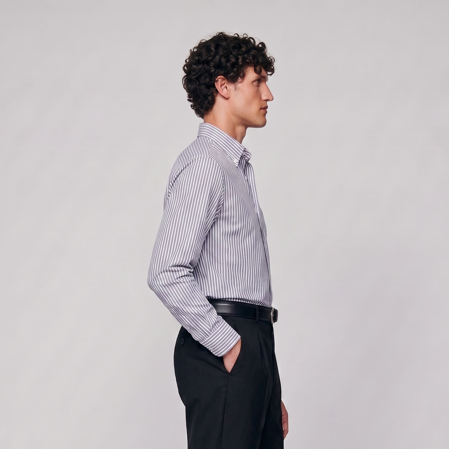 Side profile of male model wearing navy blue striped Oxford shirt