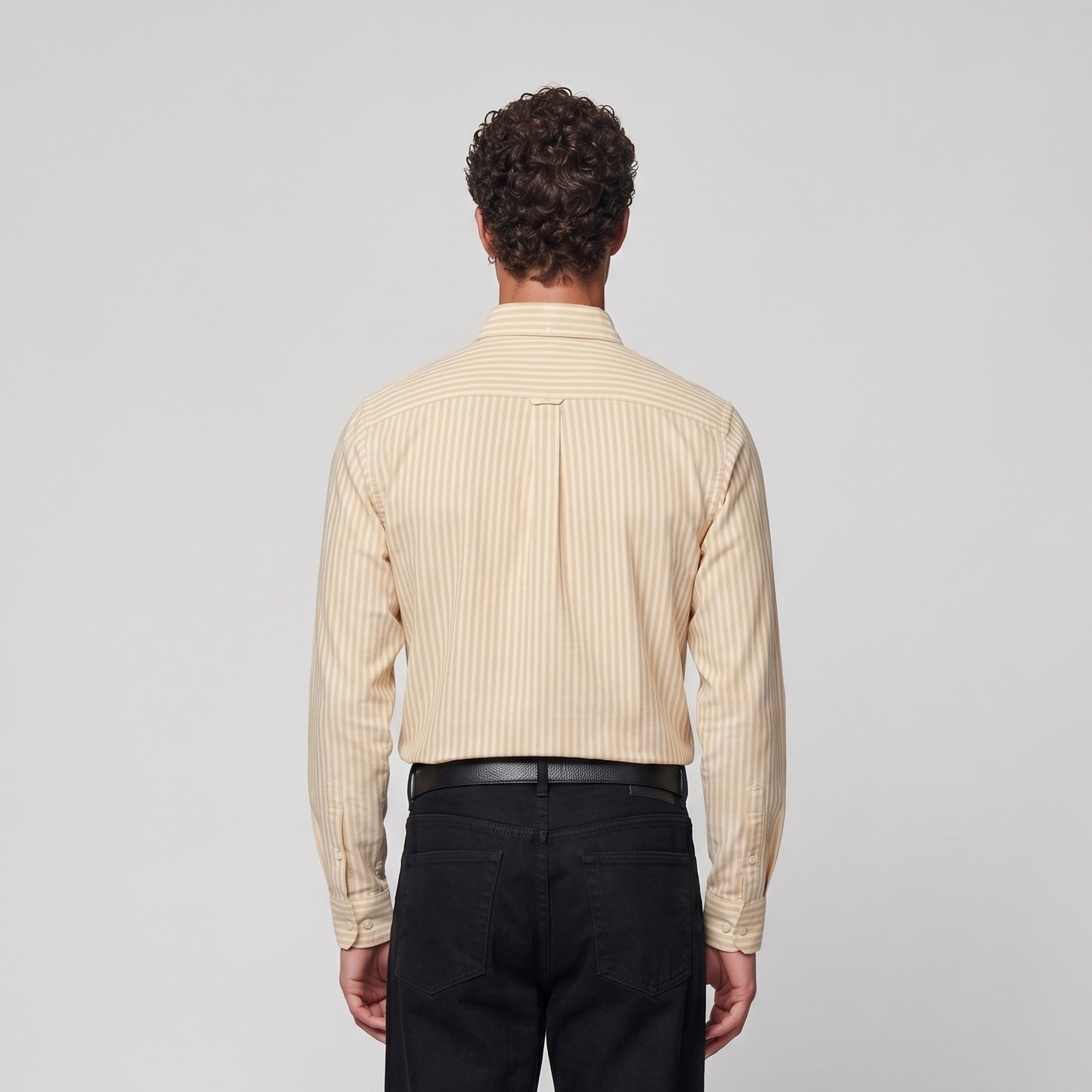 Back view of male model wearing pastel yellow striped Oxford shirt