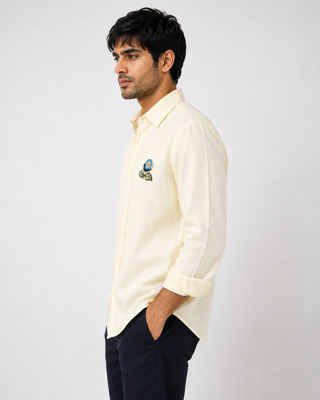 Side profile of male model wearing premium butter yellow embroidered linen shirt