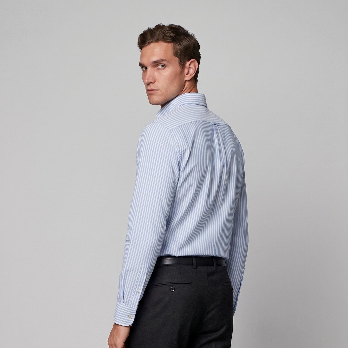 Back view of male model wearing premium sky blue striped Oxford shirt