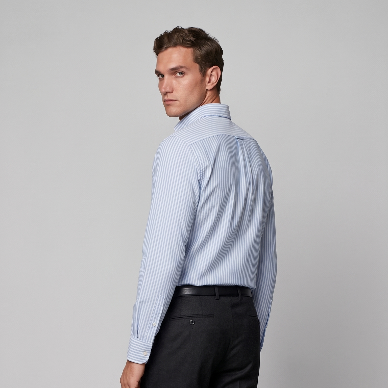 Back view of male model wearing premium sky blue striped Oxford shirt